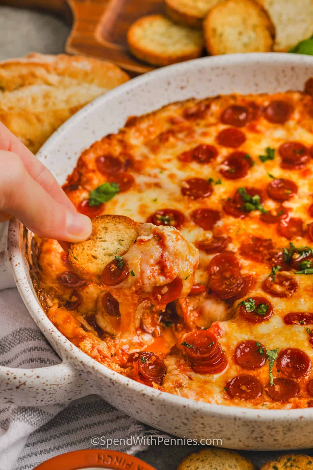 dipping bread in Easy Cheesy Pizza Dip