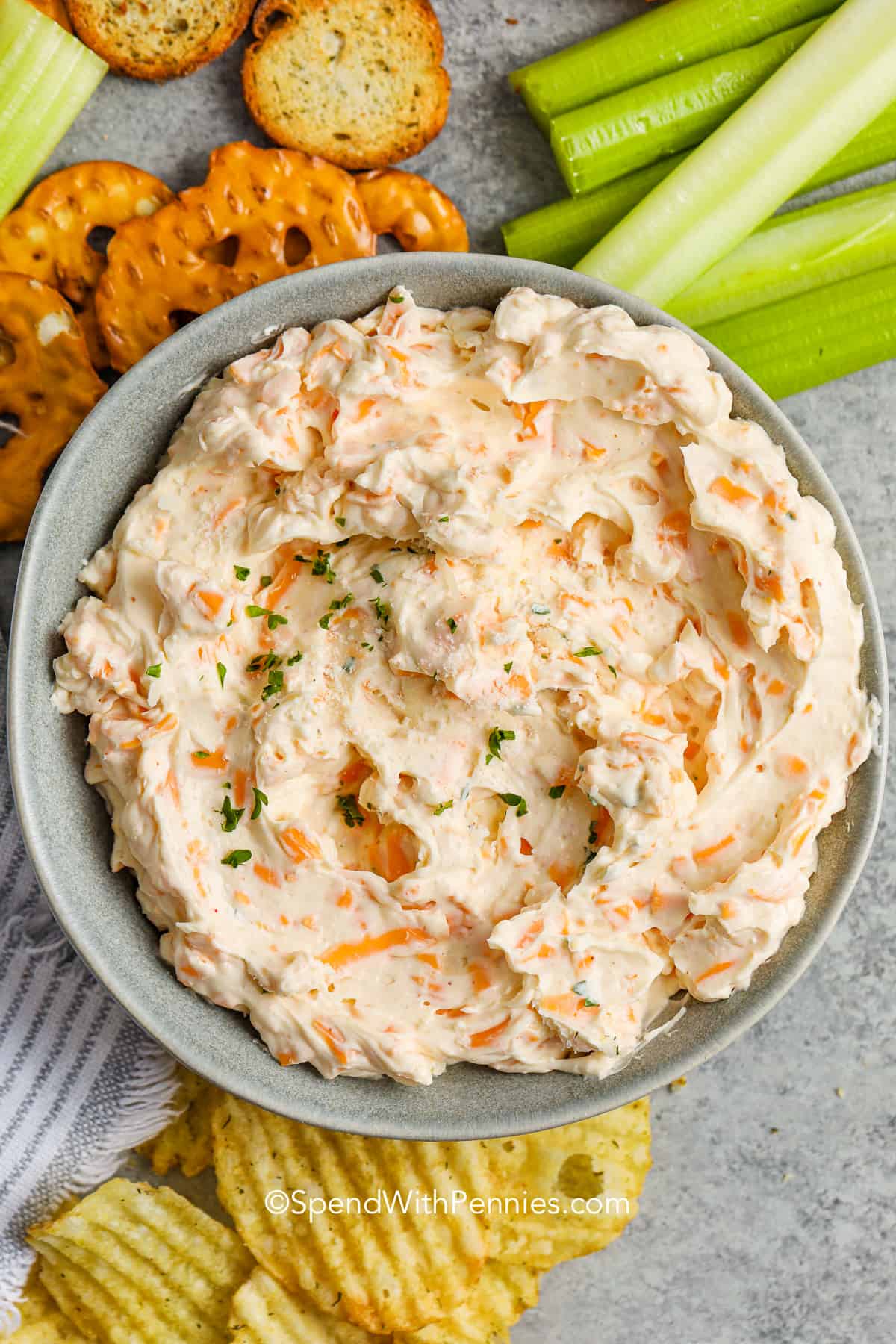 cheese dip in a bowl with chips and veggies for dipping